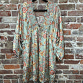 sage floral long-sleeve dress with a smocked v-neck border and front ties on a hanger