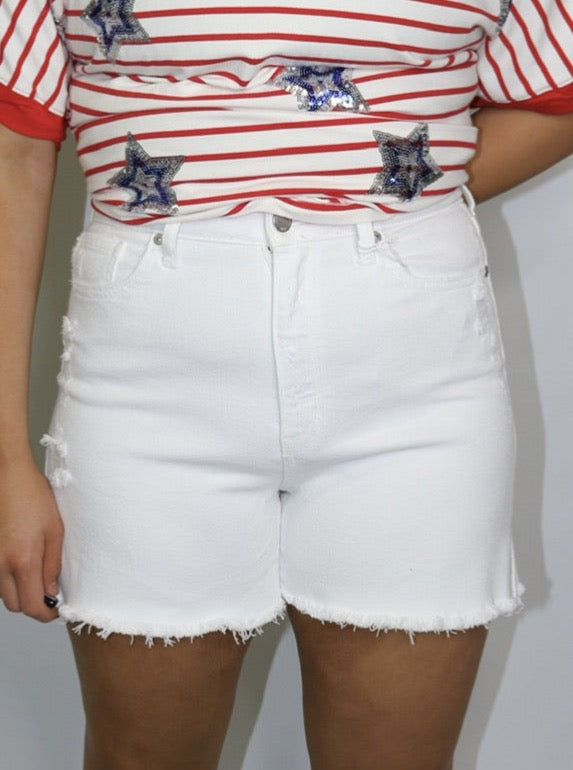 close-up of white high-waisted denim shorts with front pockets and frayed hems