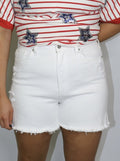 close-up of white high-waisted denim shorts with front pockets and frayed hems
