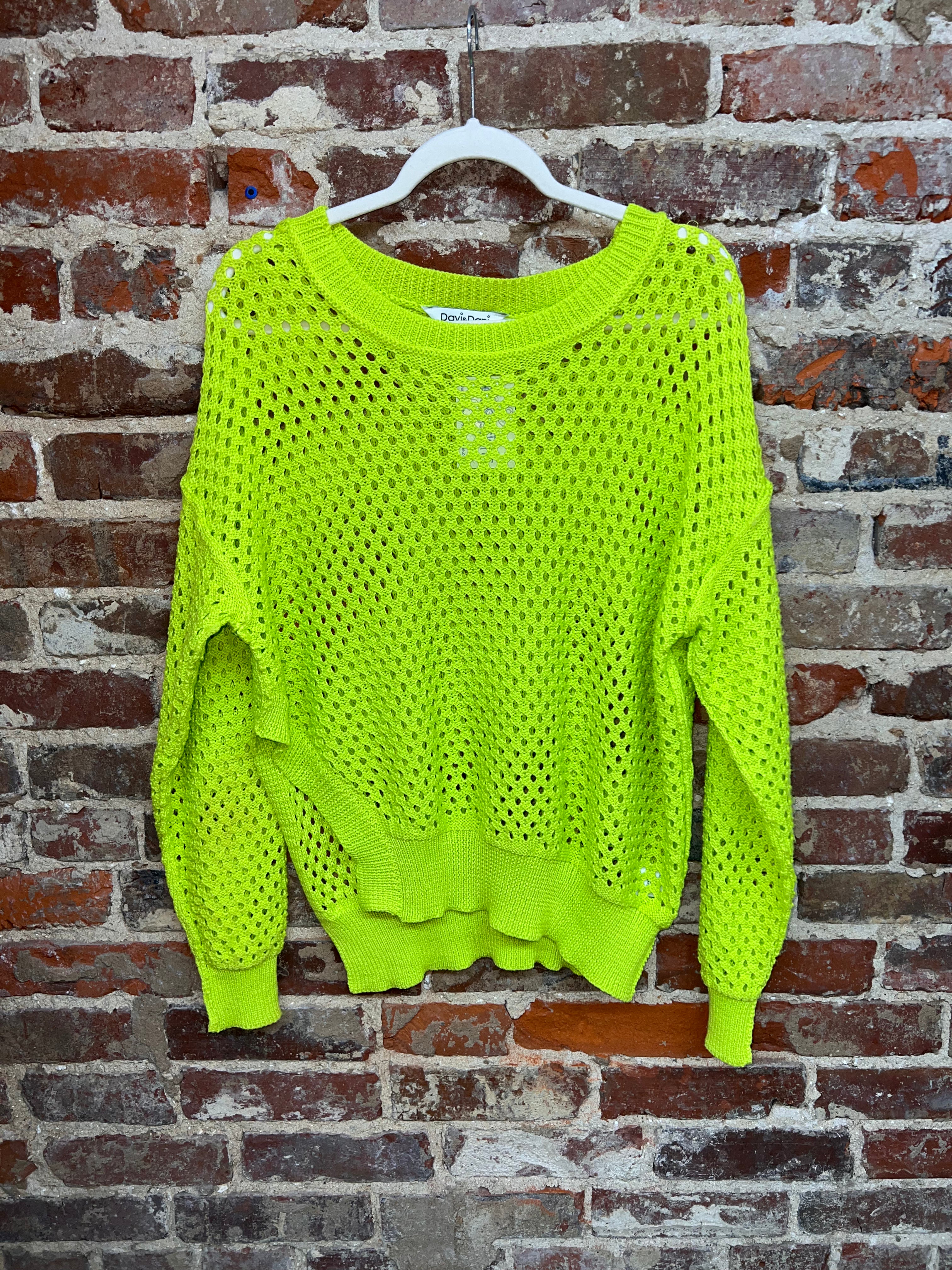 neon yellow-green open-knit long-sleeve sweater with a round neckline on a hanger