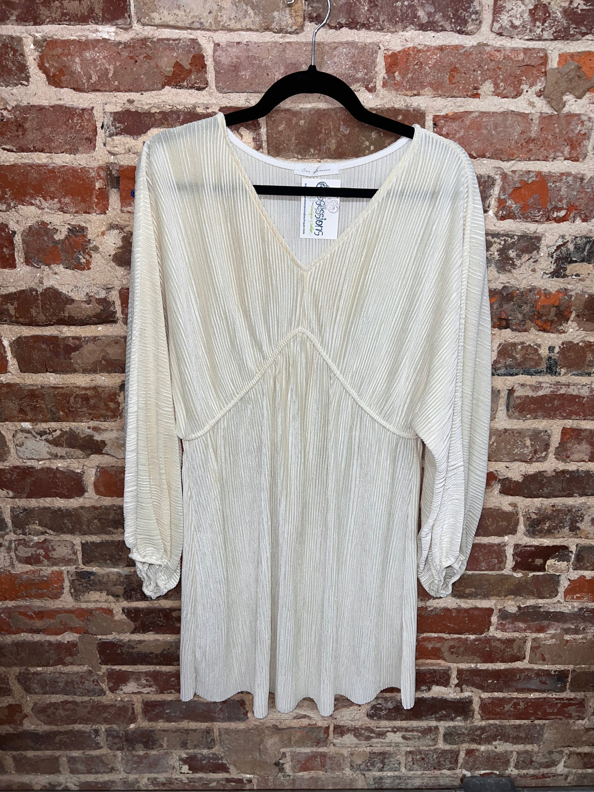 front view of an ivory pleated long-sleeve dress with a v-neck and raised waist seam