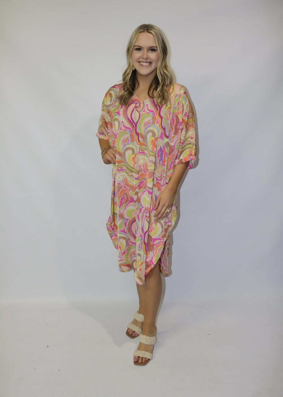 front view of a pink abstract-print midi dress with loose elbow-length sleeves and a curved hem